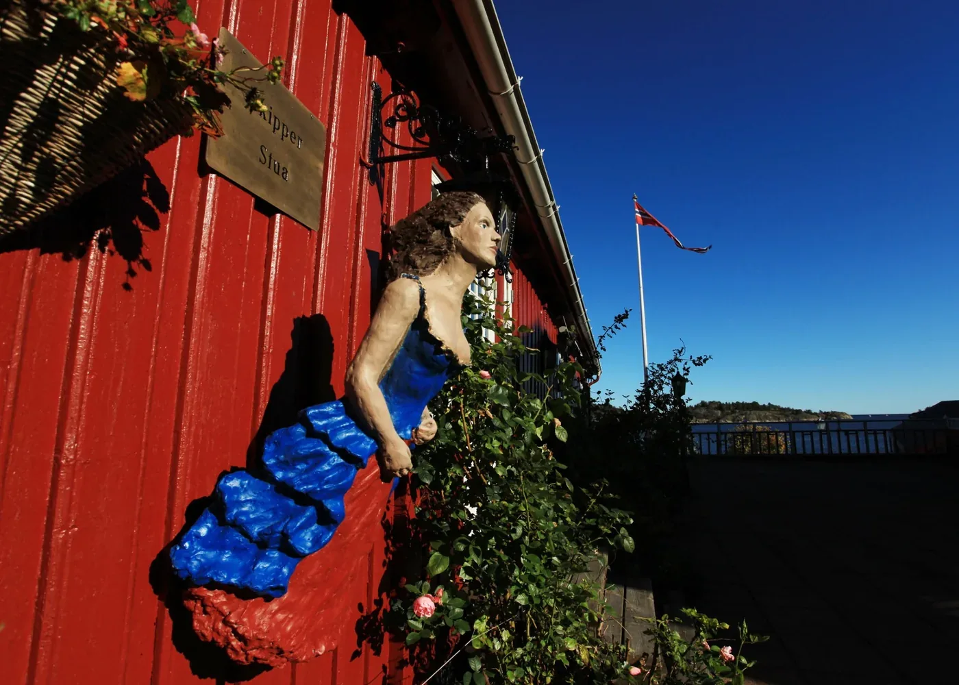 Skipperstua ved sjøen med rødt trehus og utsikt
